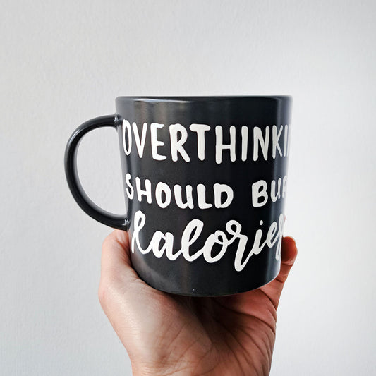 Hand painted black ceramic mug, "Overthinking should burn Calories"