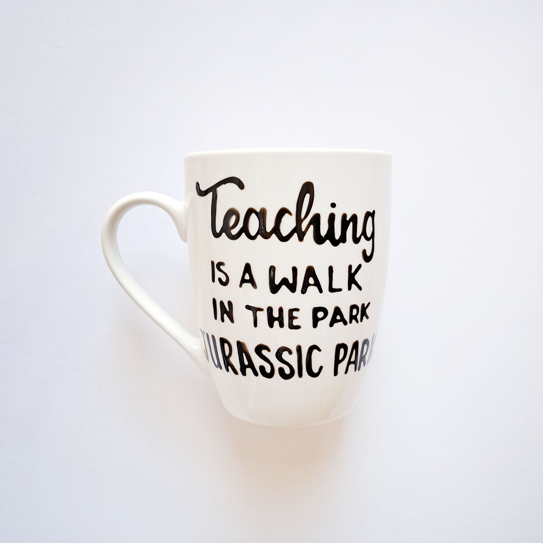 Hand painted black ceramic mug, "Teaching is a walk in the park"